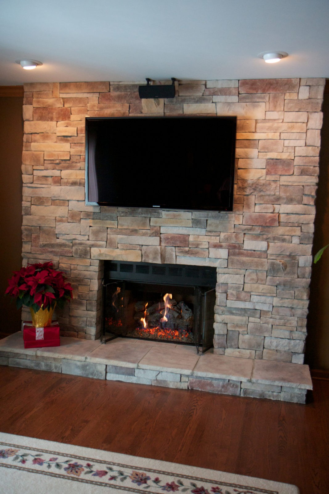 Mountain stack stone veneer fireplace with poinsettias