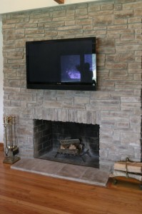 Gray mountain stack stone veneer fireplace with a stone hearth