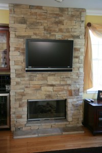 Mountain stack stone veneer fireplace in a yellow room
