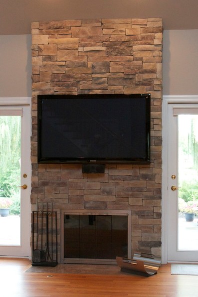 Mountain stack stone veneer fireplace with a TV and no mortar joint