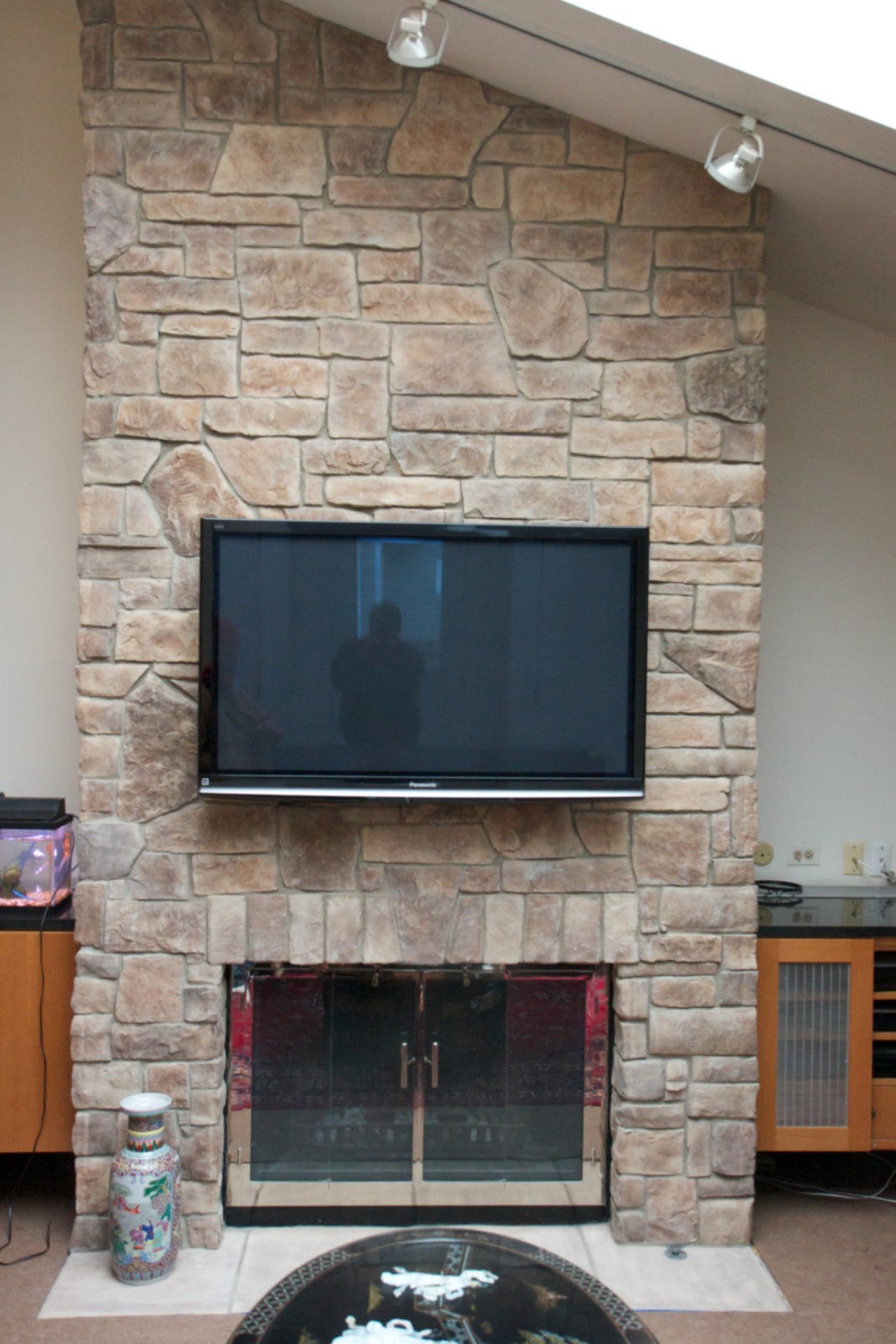 Light cobblestone fireplace with a TV