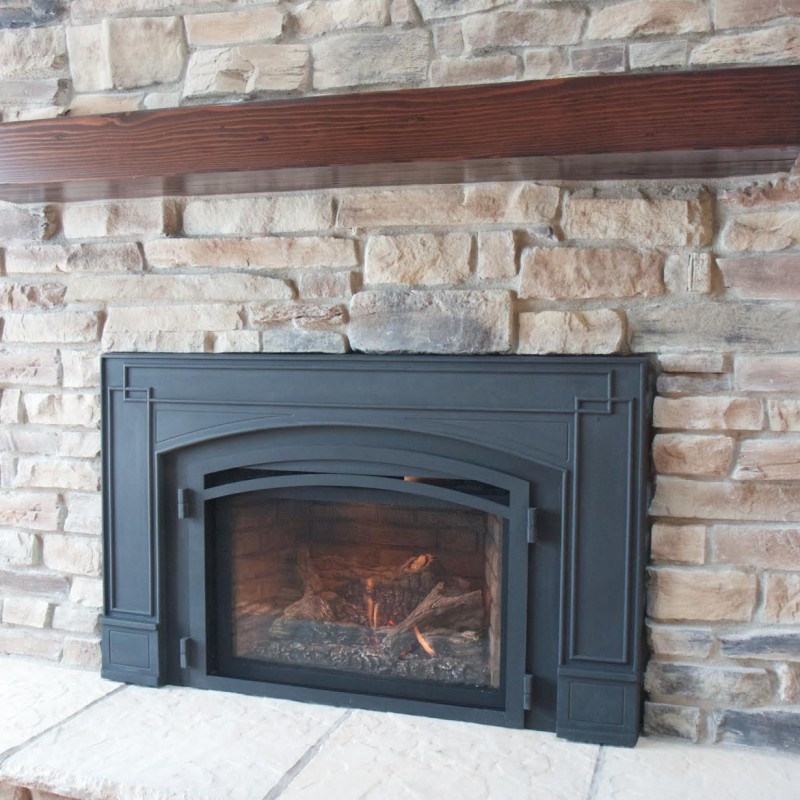 Our stone work: a stone veneer fireplace with a wooden mantle