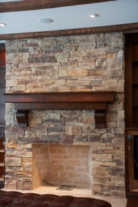 Mountain ledge stone veneer fireplace surrounded by wooden built-in cabinets