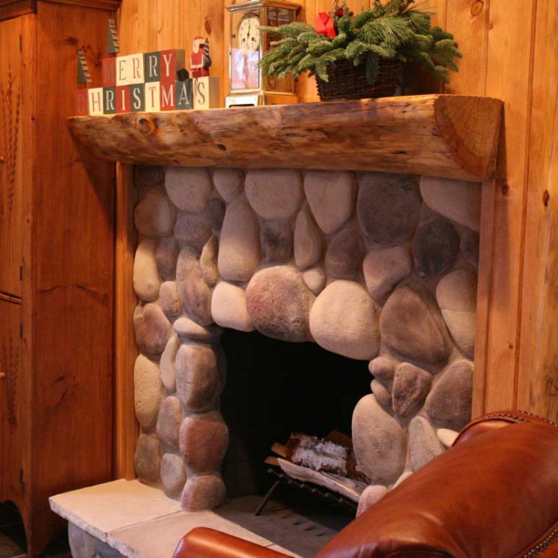 River Rock stone veneer fireplace with a log mantle and Christmas decorations