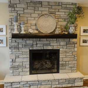 Custom stone veneer fireplace with a wooden mantel